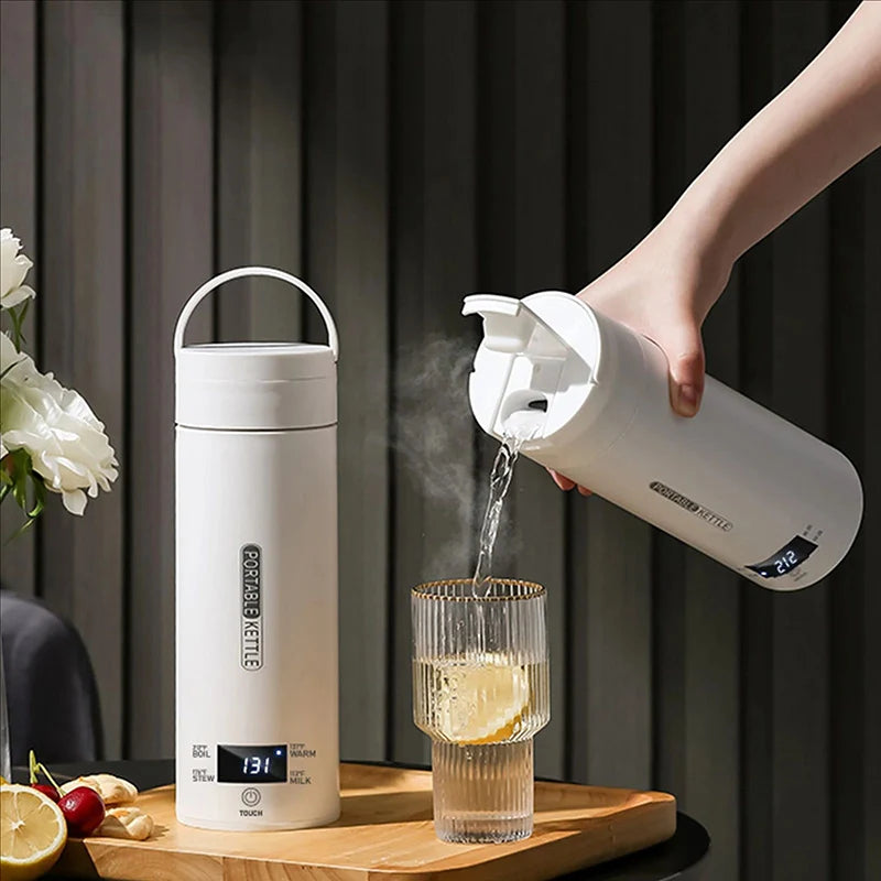 White electric thermos bottle being used to pour water into a glass on a wooden tray with a dark curtain background.