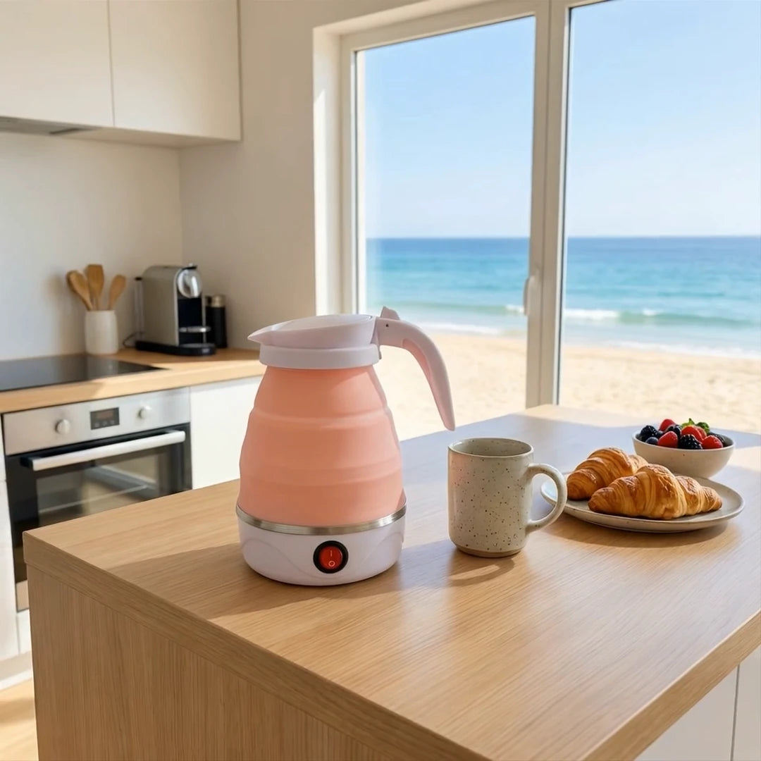 Pink electric kettle on a kitchen counter with a scenic view of the ocean.