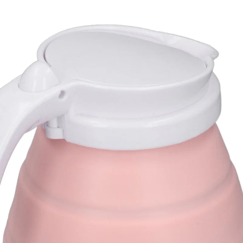 Pink foldable electric kettle with white lid on a white background