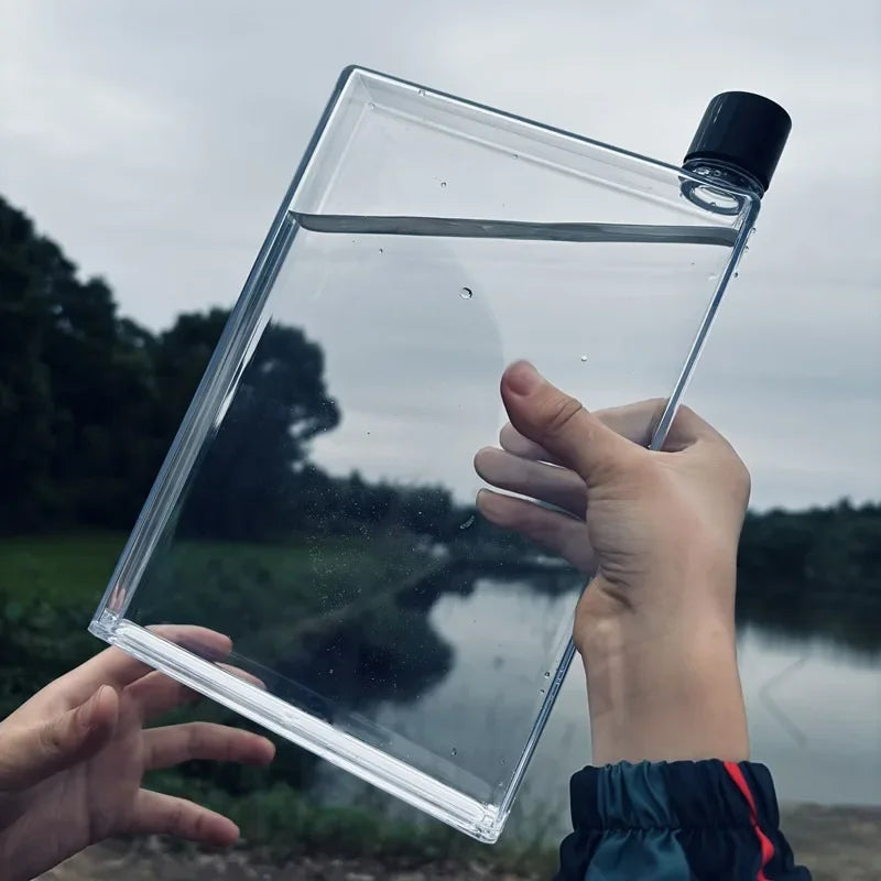 Clear plastic container held by a person with a natural background