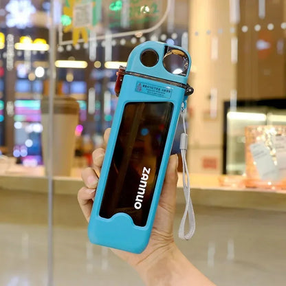 Hand holding a green square water bottle in an indoor setting.