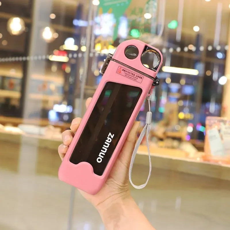 Pink square water bottle with camera lens attachment held by a hand in front of a blurred indoor background