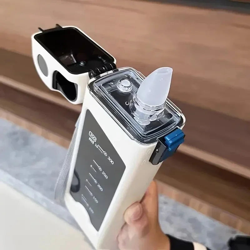 Hand holding a white square water bottle with lid flipped open.