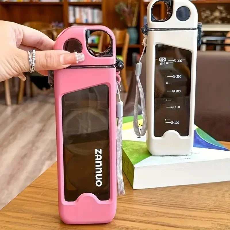 Pink water bottle with a transparent side panel displaying on a wooden surface.