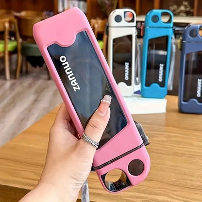 Pink square sports bottle held by a hand, with more water bottles in the background.