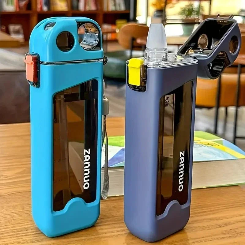 Two square sports bottles on a wooden table with a blurred indoor background.