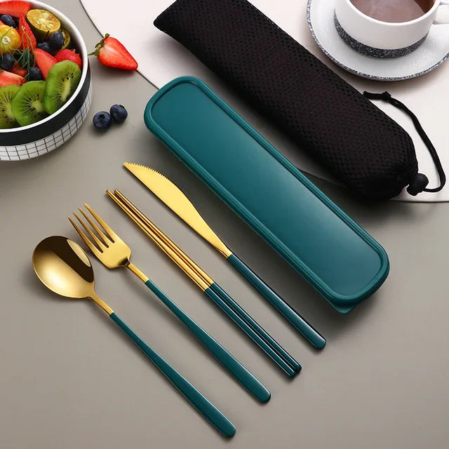 Teal and gold cutlery set with a carrying case on a table with fruits and a cup.