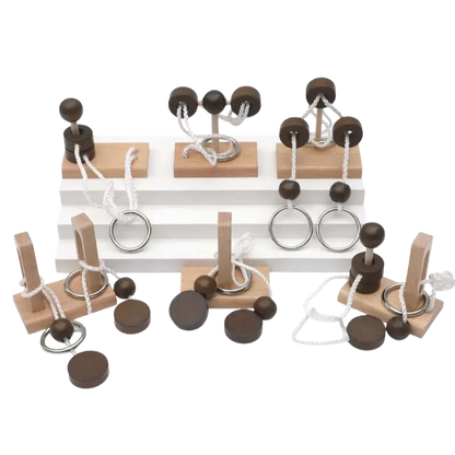 Assortment of different wooden rope untie puzzles laid out on a transparent background.